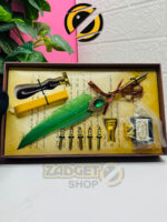 Open vintage calligraphy set containing a green quill pen, five interchangeable nibs, black ink, wax stick and seal stamp