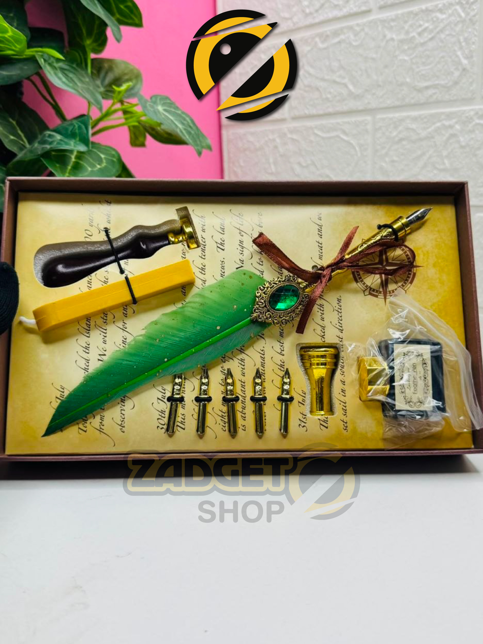 Complete green feather dip pen set with five nibs, ink bottle, wax seal stamp and yellow sealing wax arranged inside a vintage gift box