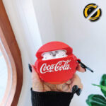 Red cola-style AirPods Pro silicone case with metal carabiner on white background
