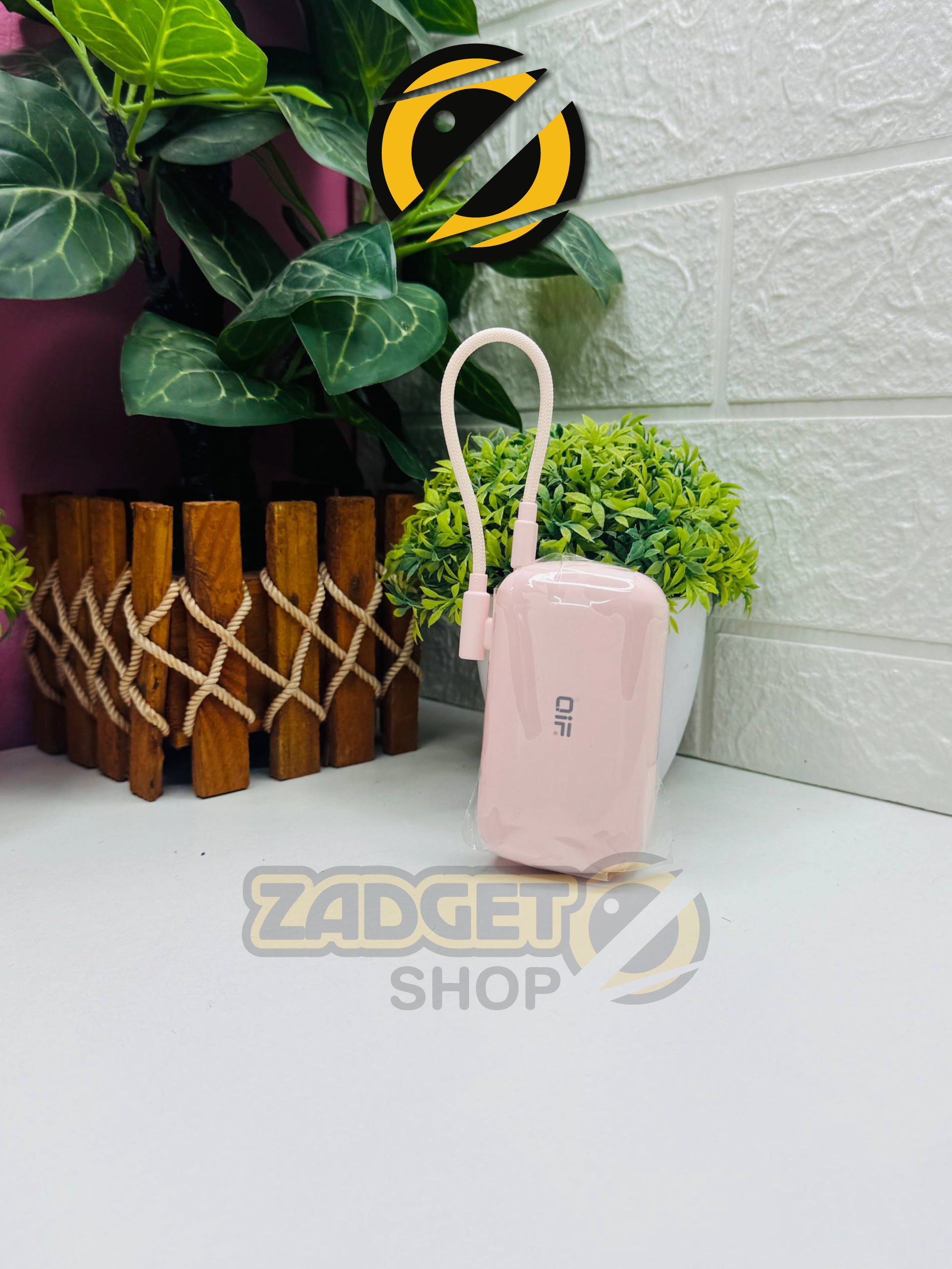 Pink QIF QY-54 10000mAh portable power bank with built-in charging cable standing upright