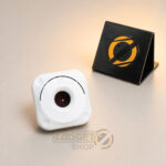 White mini hidden camera detector front view with central red lens-viewing filter